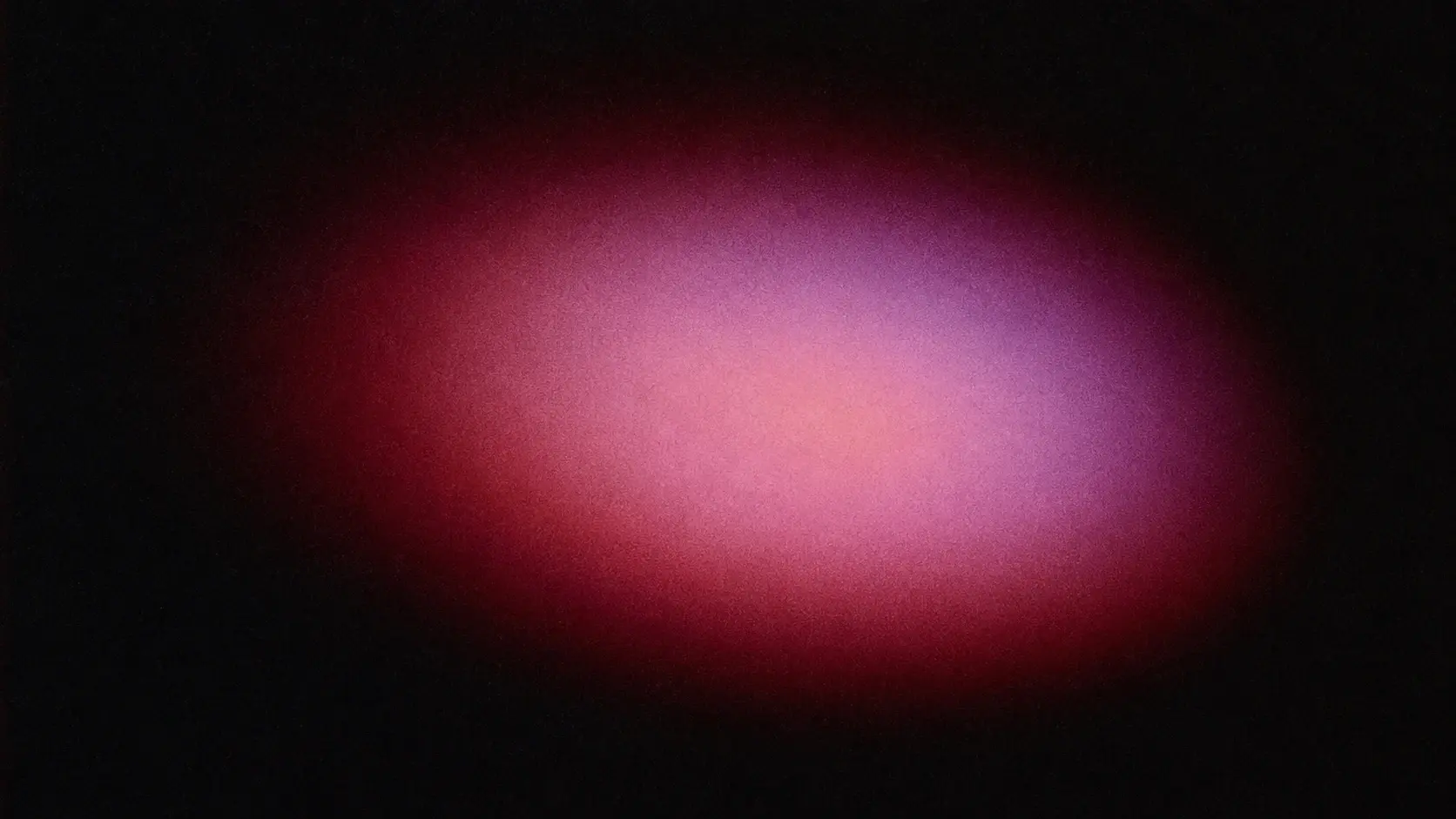 Minimal abstract color photograph, 16:9 landscape, pure black background, one huge imperfect glowing oval hovering slightly off-center, deep burgundy around the perimeter, transitioning through wine red, dusty peach, muted lavender and soft pink toward the center, heavily diffused edges dissolving into black, subtle halo, dense fine film grain, imperfect analog noise, low-light photographic texture, sophisticated and mysterious, no geometric precision, no objects, no text